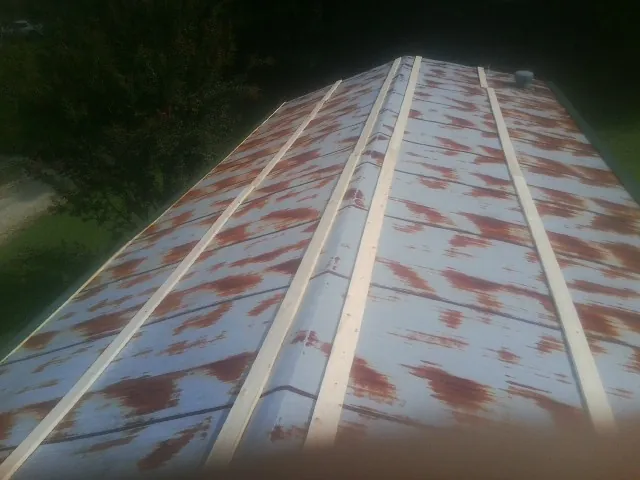 Rusted metal roof panels with new wood purlins before replacement — Storm Damage Roof Repair in Baytown by Roofing Brothers