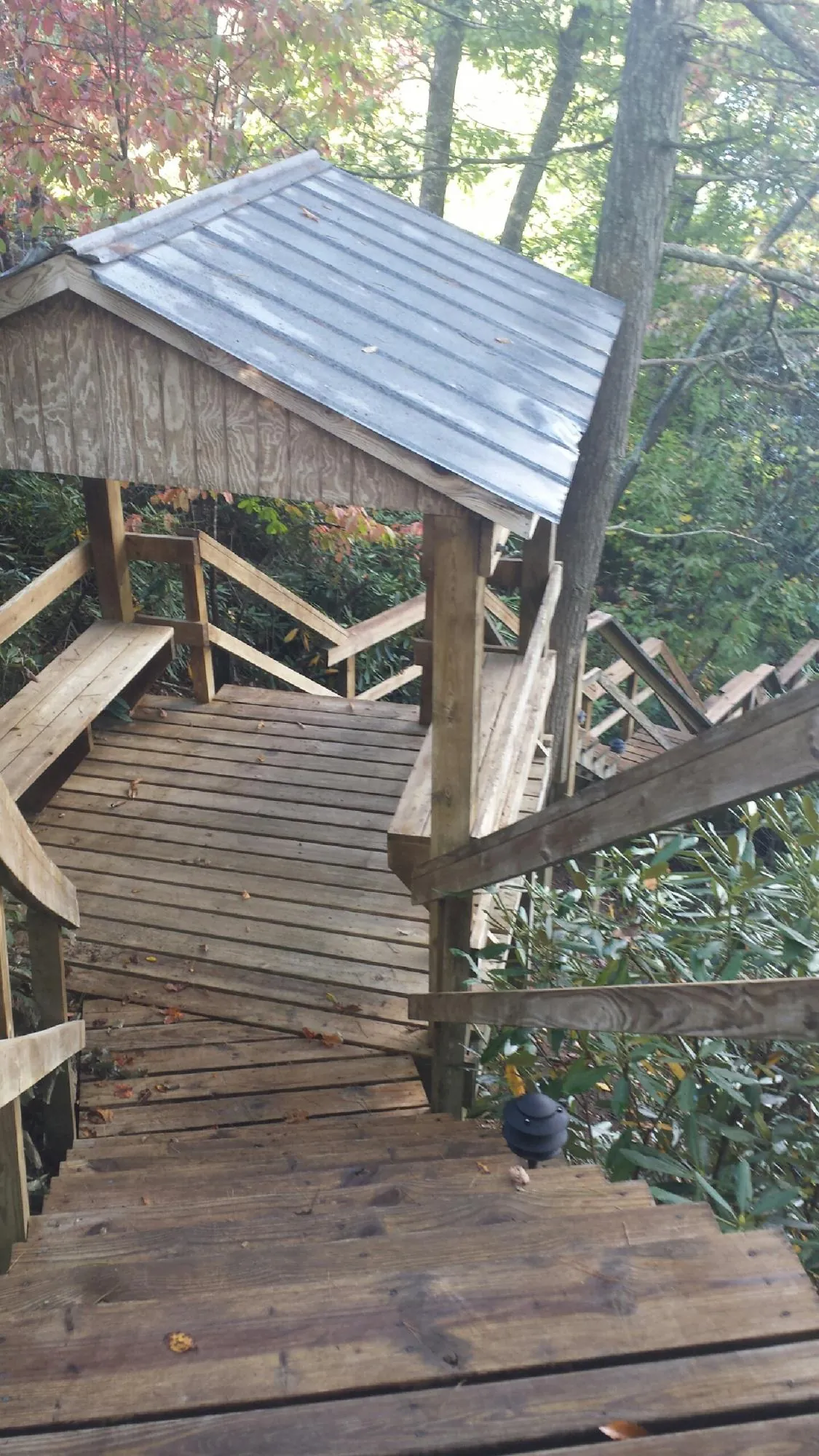 Metal roofed shelter over wooden steps on a wooded walkway — Skylight Repair & Installation work by our crew in Baytown