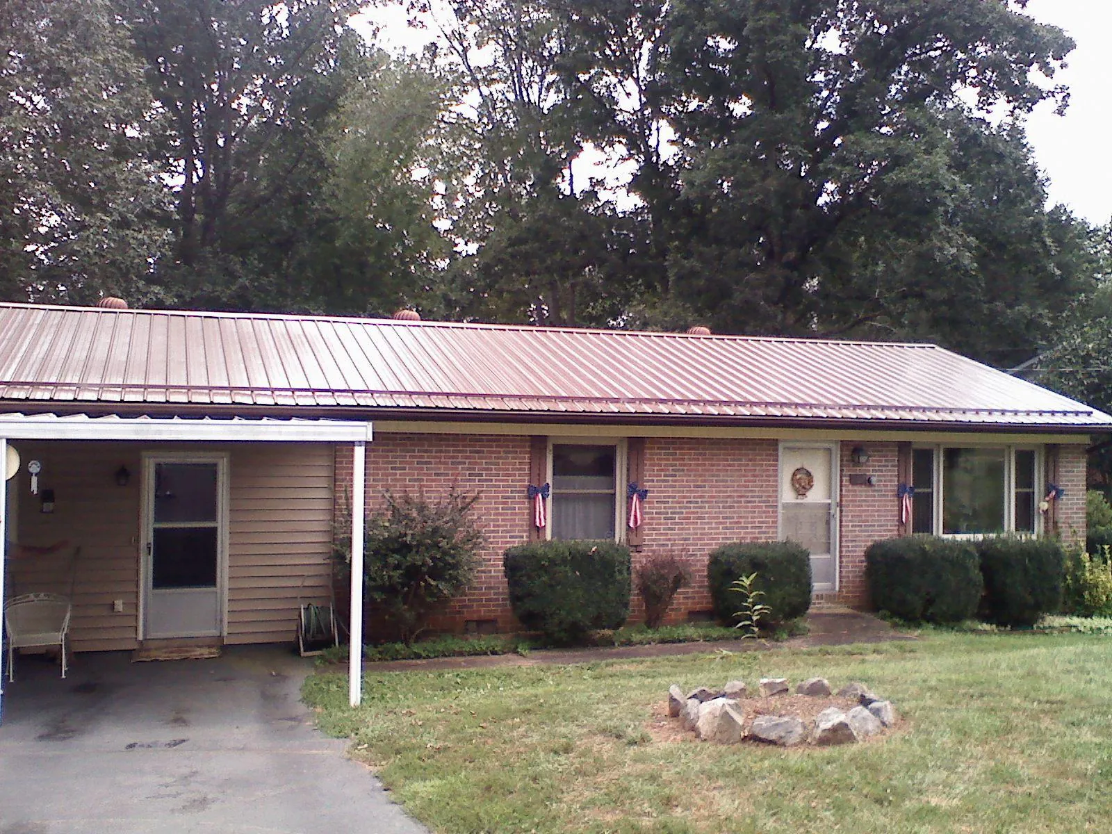 Bronze metal roof and carport on a brick ranch home — Roof Repair work by our crew in Baytown